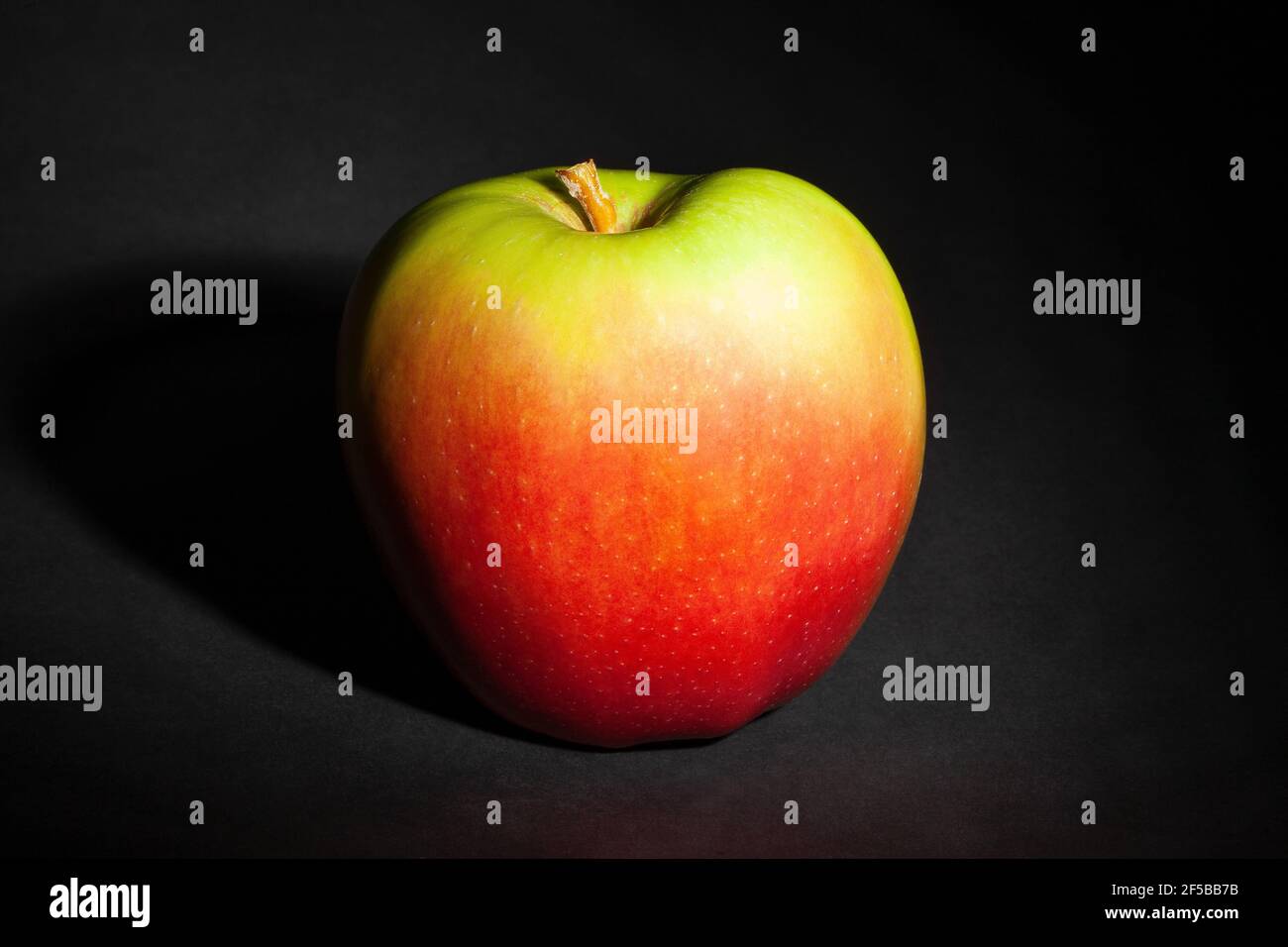 Rot grüner Apfel auf schwarzem Hintergrund Stockfoto