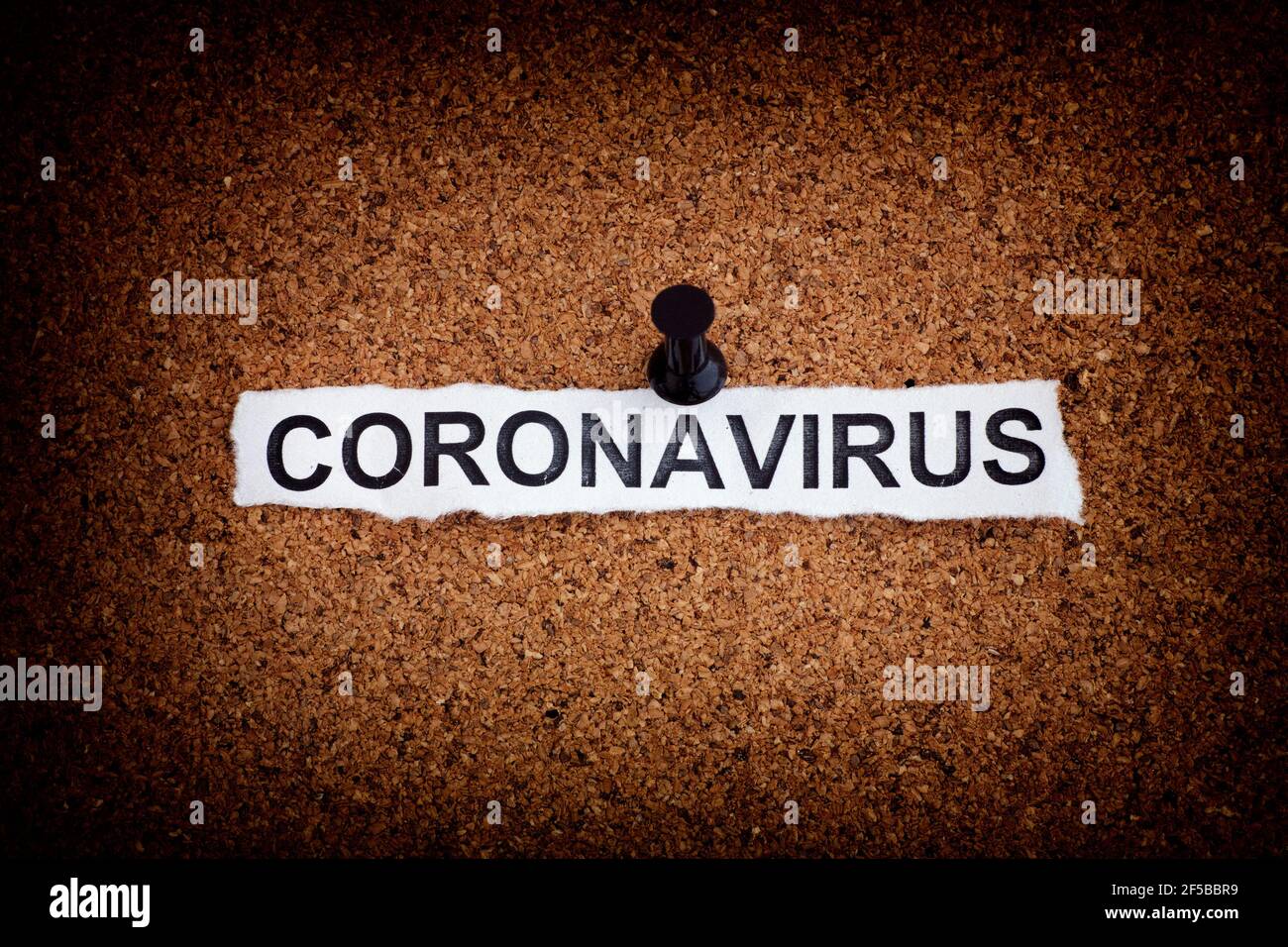 Coronavirus. Zerrissenes Stück Papier mit dem Wort Coronavirus auf einem Korkbrett. Nahaufnahme. Stockfoto