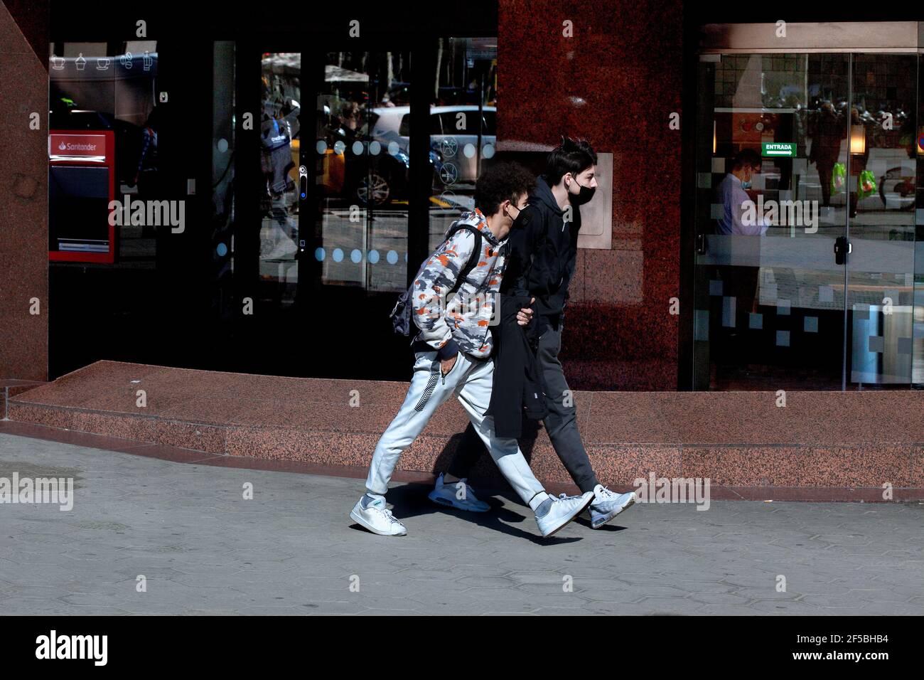 Zwei junge Männer, die auf der Straße in Barcelona spazieren. Stockfoto