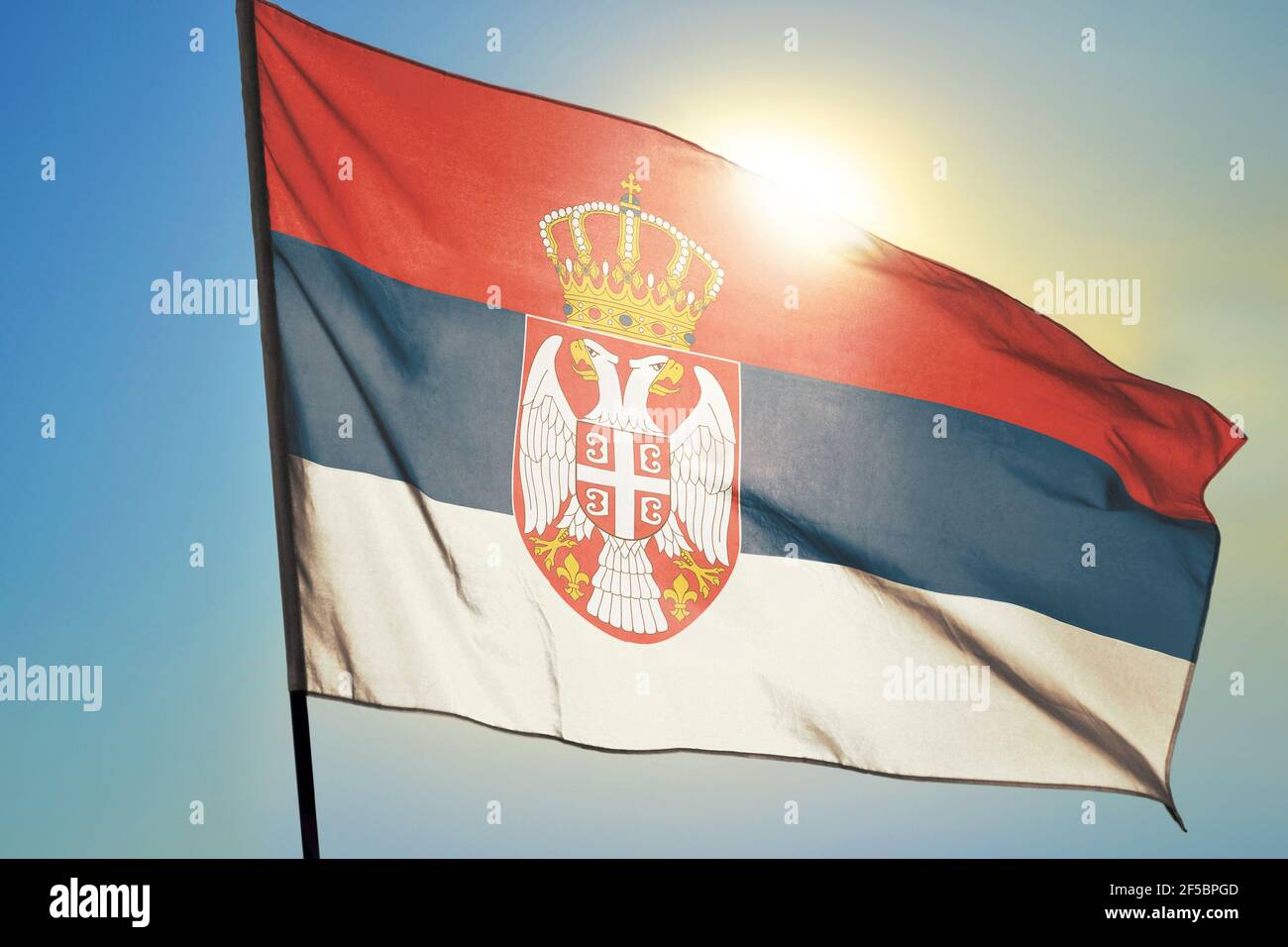 Serbien Flagge winkt auf dem Wind vor der Sonne Stockfoto