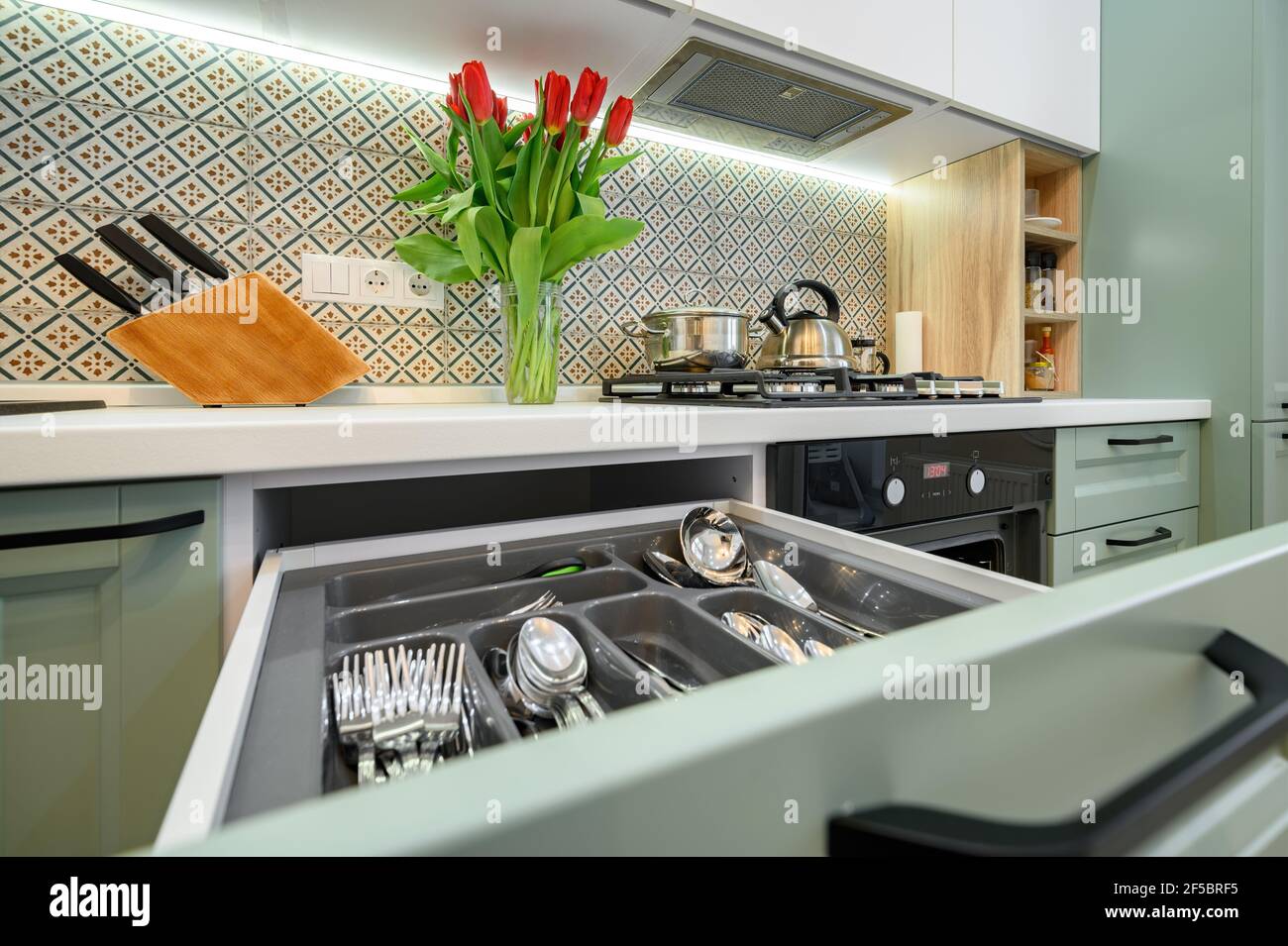 Schubladen herausgezogen in Schrank bei Luxus-blaugrün und weiß Moderne Küchenmöbel Stockfoto