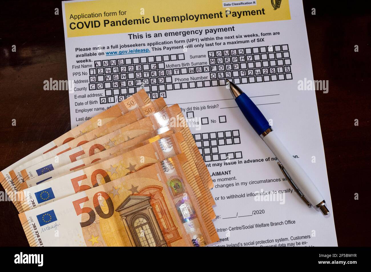 Irish COVID-19 Pandemic Arbeitslosigkeit Zahlung Antragsformular mit €50 Noten. Stockfoto