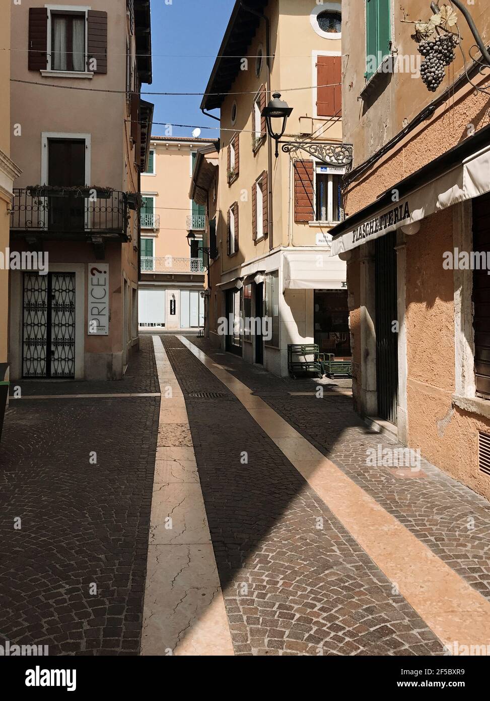 Bardolino, Italien. März 2021, 25th. Blick auf die Via Alberto im Stadtzentrum von Bardolino, am Mittag (11,41CET). Jedes Jahr kommen tausend Touristen im Frühjahr an, heute am fünften Tag des Frühlings, die Straßen sind leer, und der Einzelhandel während der dritten Welle der Covid-19 Epidemie geschlossen. In Bardolino, Italien, 25. März 2021. Quelle: ALEJANDRO SALA/Alamy Live News Stockfoto