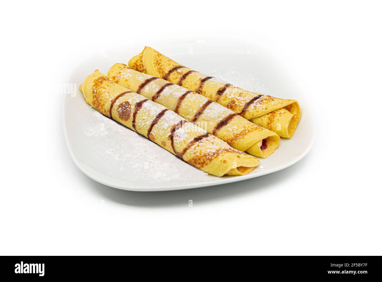 Leckere hausgemachte Crepes oder Pfannkuchen mit Waldfrucht-Marmelade oder Schokoladencreme auf weißem Hintergrund. Stockfoto