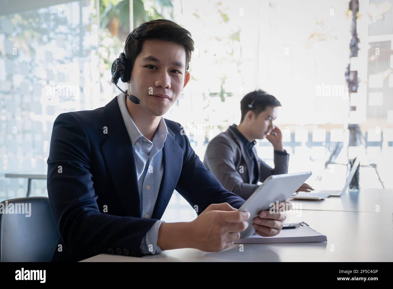 Kundendienstmitarbeiter mit freihändiges Headset, das im Büro arbeitet. Stockfoto