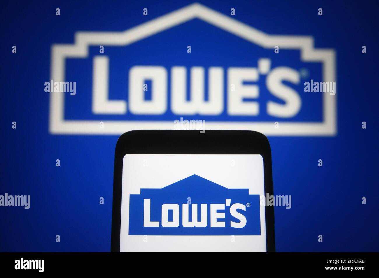 In dieser Abbildung ist das Lowe-Logo eines US-Handelsunternehmens auf einem Smartphone und einem pc-Bildschirm zu sehen. Stockfoto