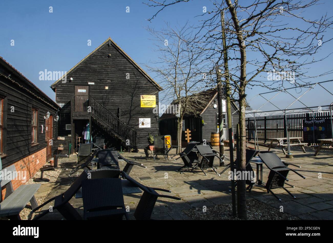 Wokingham, Großbritannien - 28. Februar 2021: Tische und Stühle im Sonnenschein des Holme Grange Craft Village in Wokingham, Berkshire. Der ehemalige Bauernhof buil Stockfoto