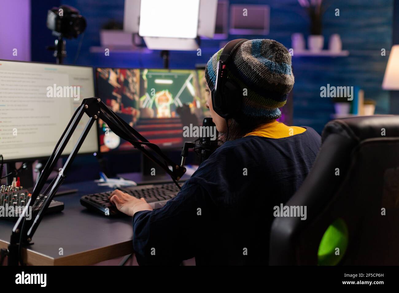 Professionelle Streamer spielen Shooter-Spiele tragen Kopfhörer und sprechen ins Mikrofon über Streaming-Chat. Gamer macht Online-Videospiele mit neuen Grafiken auf leistungsstarken Computer Stockfoto