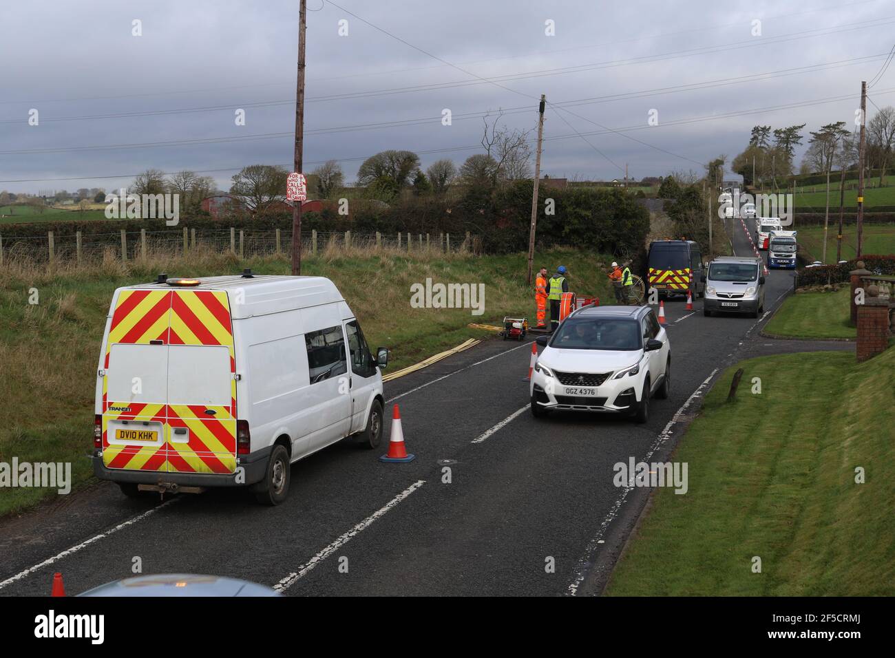 Arbeiter installieren ein Glasfaserkabel unter einer Landstraße außerhalb von Lisburn, Nordirland, Großbritannien Stockfoto