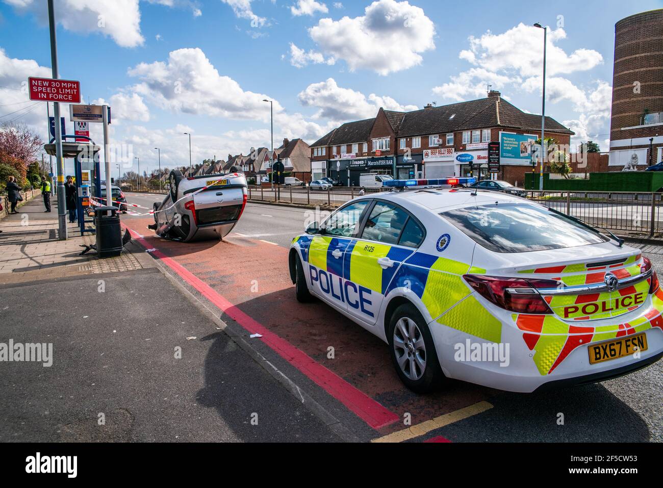 Polizei am Ort eines umgedrehten Autos an einer Bushaltestelle, einem Citroen, auf A34 Walsall Road, Great Barr, Birmingham, Großbritannien Stockfoto