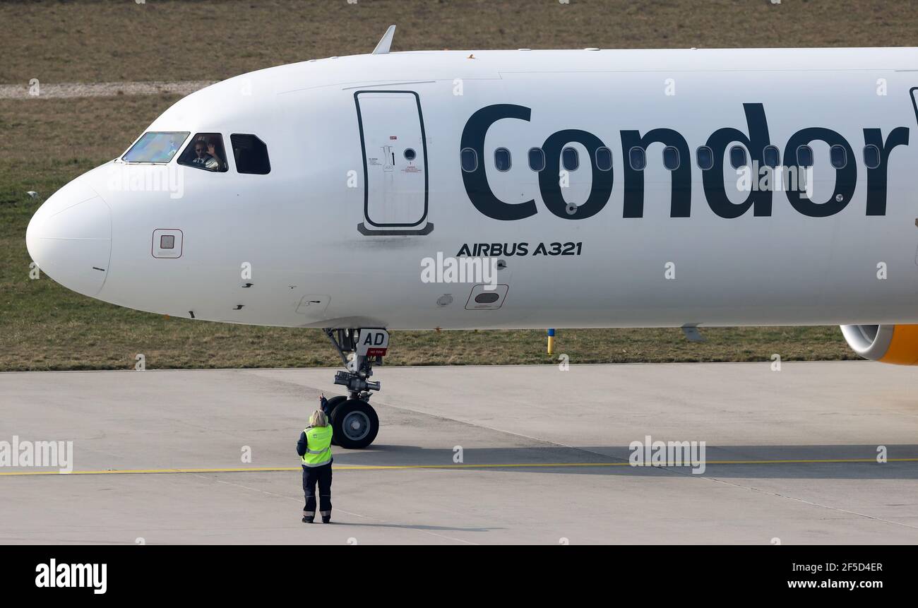 Schkeuditz, Deutschland. März 2021, 26th. Der Pilot eines Condor-Flugzeugs, das nach Teneriffa fliegt, winkt vor dem Start vom Flughafen Leipzig/Halle zum Bodenpersonal. Nach einer erzwungenen Pause von mehr als vier Monaten nimmt der Flughafen Leipzig/Halle den regulären Passagierflug wieder auf. Die ersten Flugzeuge flogen nach Ägypten. Weitere Ziele sind dann die Kanaren, Antalya, Mallorca und ab nächsten Montag Wien. Quelle: Jan Woitas/dpa-Zentralbild/dpa/Alamy Live News Stockfoto