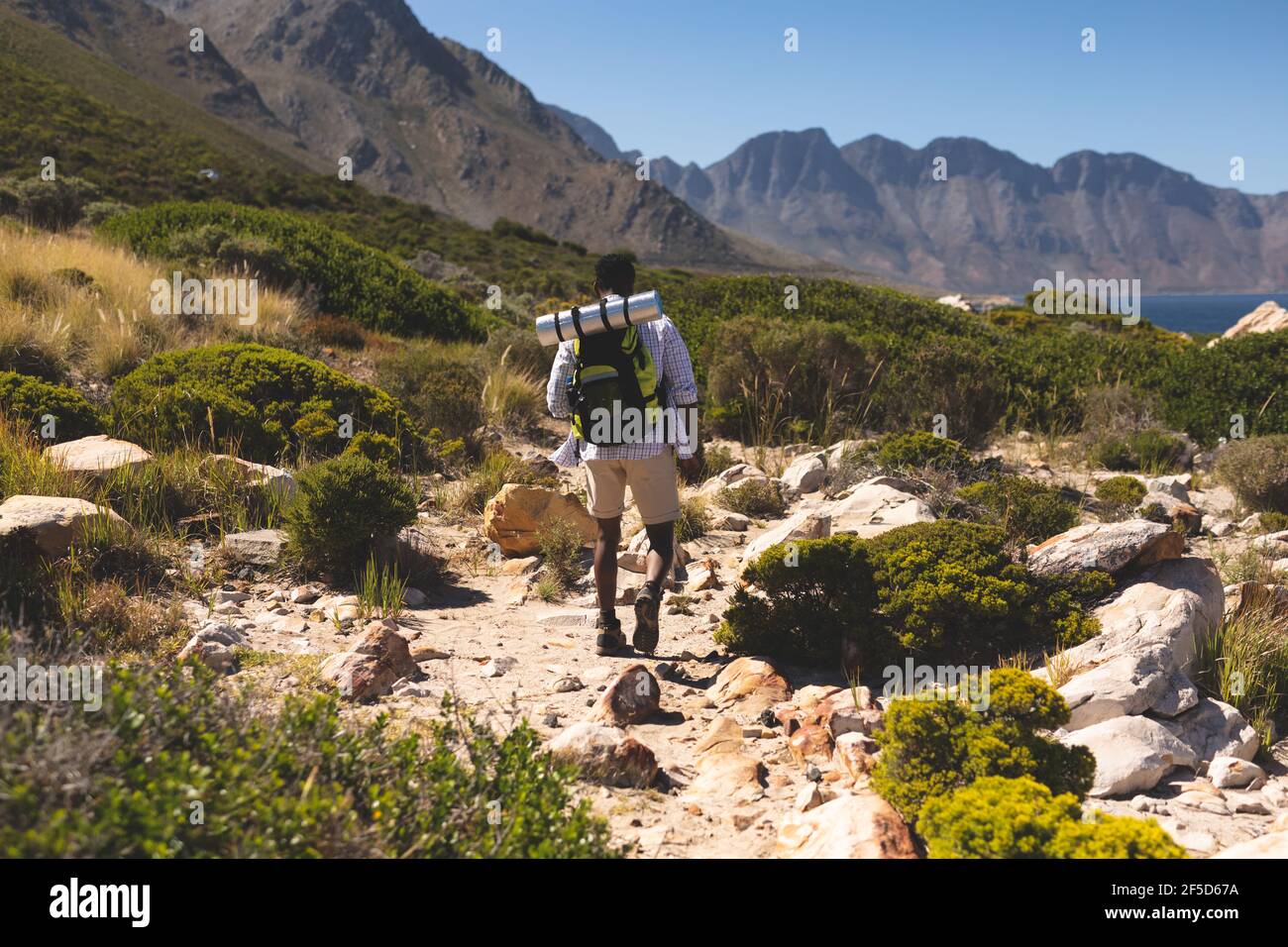 Afroamerikanischer Mann, der im Freien Wandern in der Landschaft auf einem Berg Stockfoto