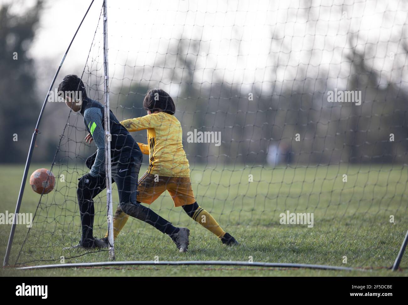 Oadby, Leiecstershire. England. März 2021. Kinder spielen Fußball in einem Park mit einem mobilen Pop-up-Tor. Stockfoto