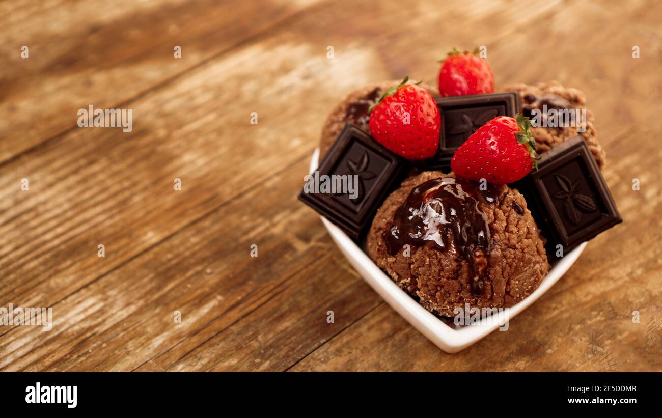 Schokoladeneis in einer Schüssel. Dessert mit Schokolade und Erdbeeren dekoriert Stockfoto