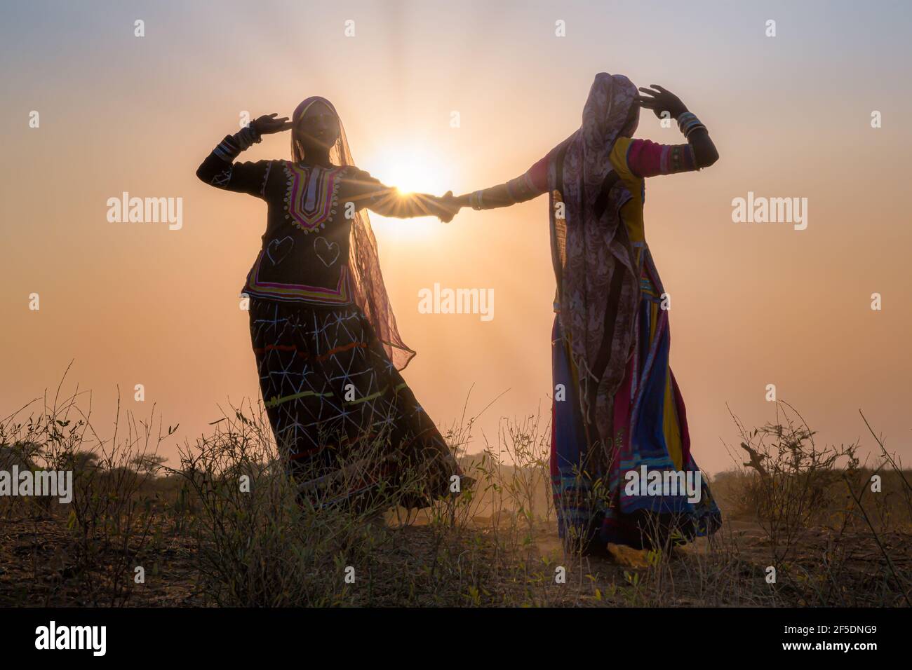Silhouetten der beiden Gypsy tanzende Frauen einen traditionellen Tanz bei Sonnenuntergang, Pushkar Camel Fair, Pushkar, Rajasthan, Indien Stockfoto