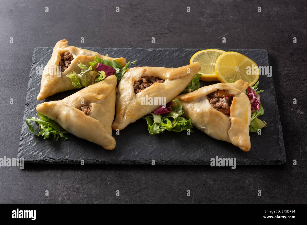 Traditioneller mittelöstlicher Fatayer auf schwarzem Schieferhintergrund Stockfoto