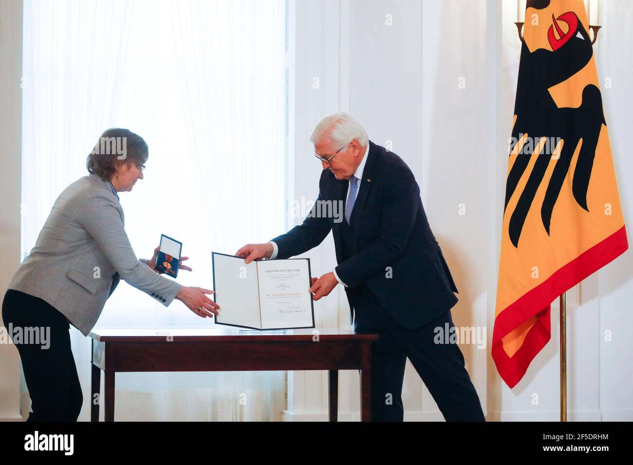 Berlin, Deutschland. März 2021, 26th. Bundespräsident Frank-Walter Steinmeier (r) würdigt Jana Fechner im Schloss Bellevue mit dem Bundesverdienstkreuz für ihre Verdienste während der Coronavirus-Pandemie. Quelle: Markus Schreiber/AP POOL/AP/dpa/Alamy Live News Stockfoto