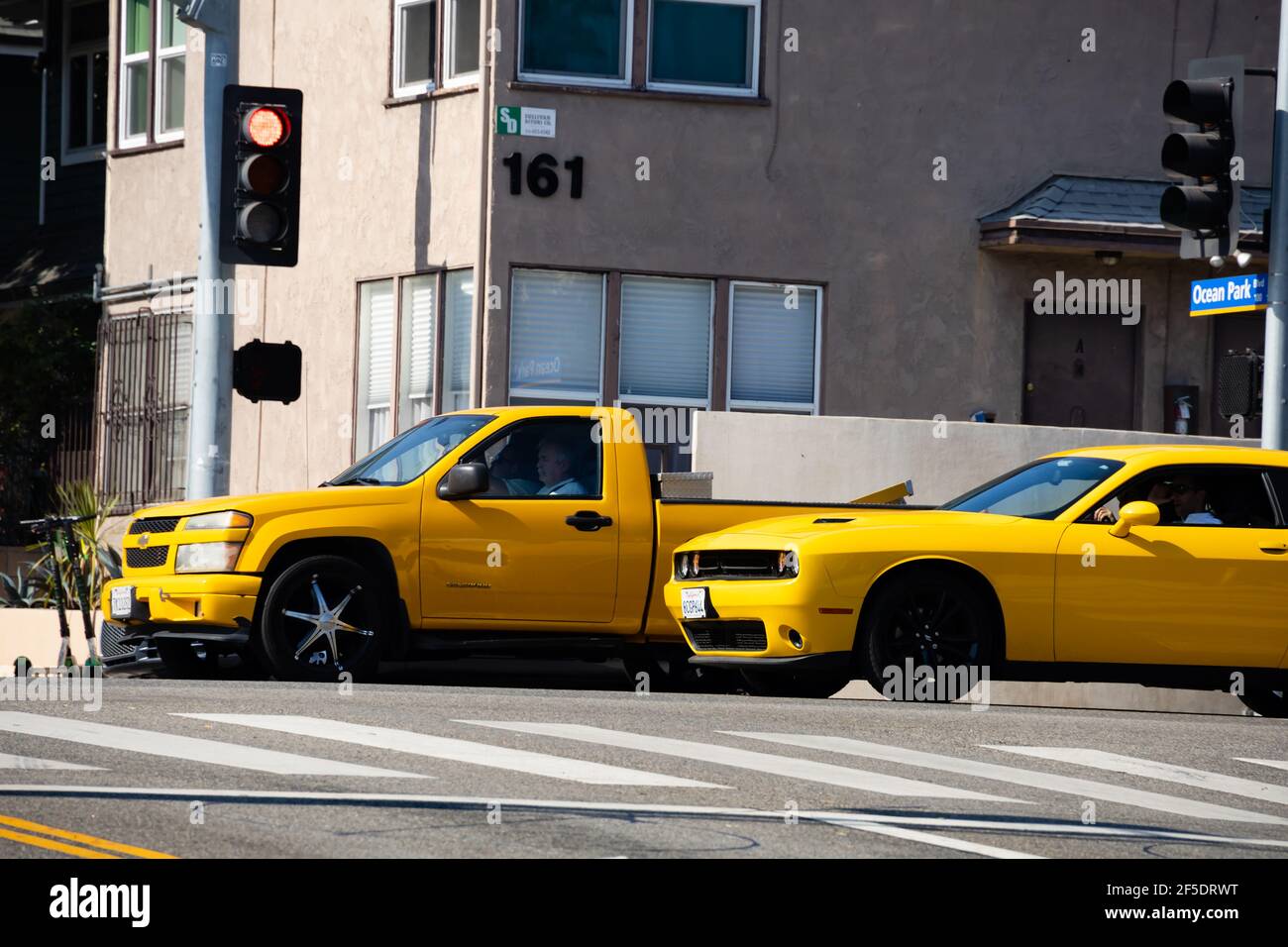 Hellgelbe Auto- und LKW-Rennen weg von der Ampel an der Kreuzung von Ocean Park Boulevard und Neilson Way. Santa Monica, Los Angeles, Stockfoto
