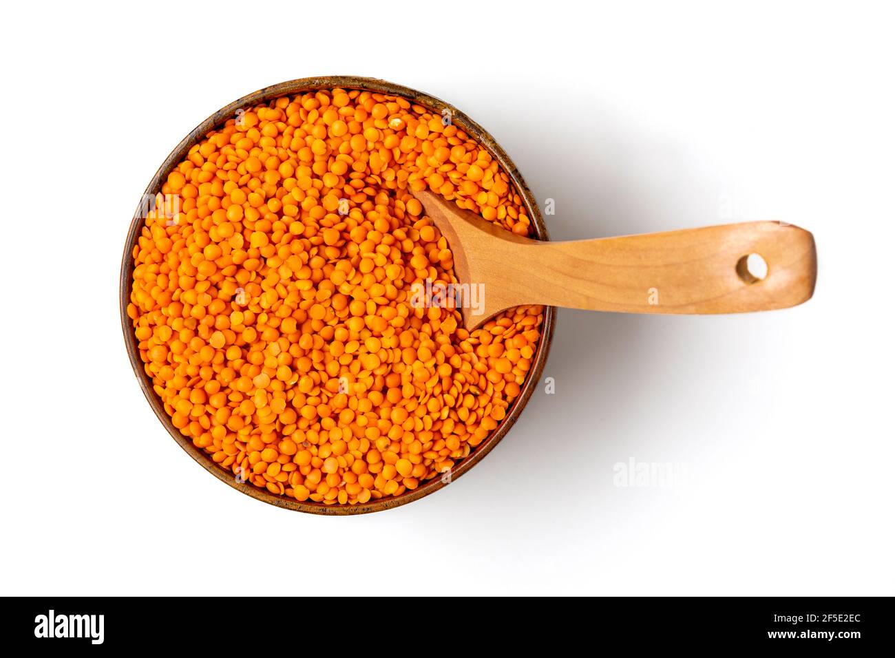 Rohe Samen von Orangenlinsen in Holzschüssel, Löffel isoliert auf weißem Hintergrund Draufsicht Flat Lay gesunde Ernährung, pflanzliches Protein-Konzept traditionell Stockfoto