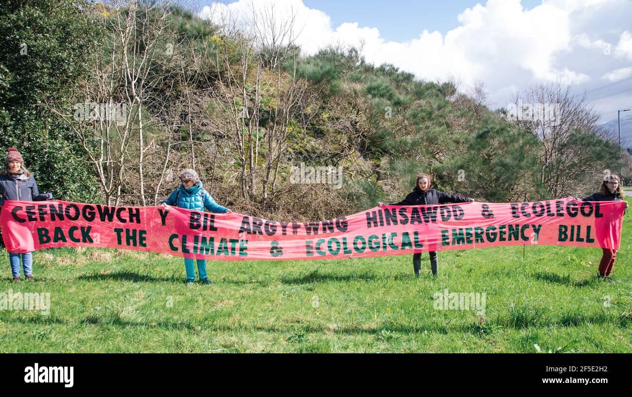 One Stop Roundabout, Bethesda, Gwynedd, North Wales, Großbritannien. 26th. März 2021. Mitglieder der Extinction Rebellion Nordwales halten ein Banner, das die Unterstützung des Klima- und ökologischen Nothilfegesetzes fordert.als Teil eines nationalen Transparenttropftages.das Parlament hat bereits 2019 eine Klimanotlage ausgerufen – aber die Demonstranten sagen, dass die Aktionen ihren Worten nicht entsprachen. Ein Notfall erfordert starkes, entschlossenes Handeln, um die Klima- und Umweltkrise umzukehren. Stockfoto