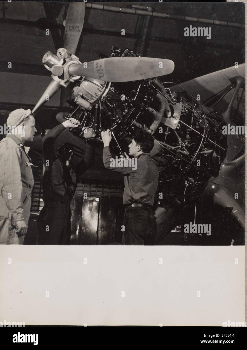 Drei Männer arbeiten an einem Flugzeugmotor. Arnold Eagle (Amerikanisch, 1909 - 1992) Stockfoto