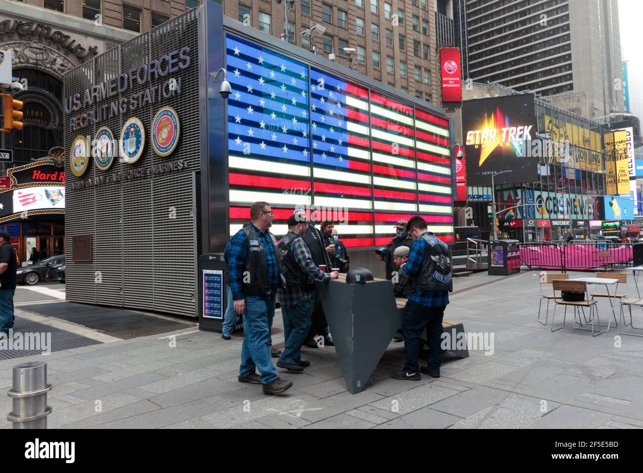 Eine Gruppe von Männern, die an einem nebligen Tag vor der Rekrutierungsstation der US-Streitkräfte auf dem Times Square in New York stehen Stockfoto