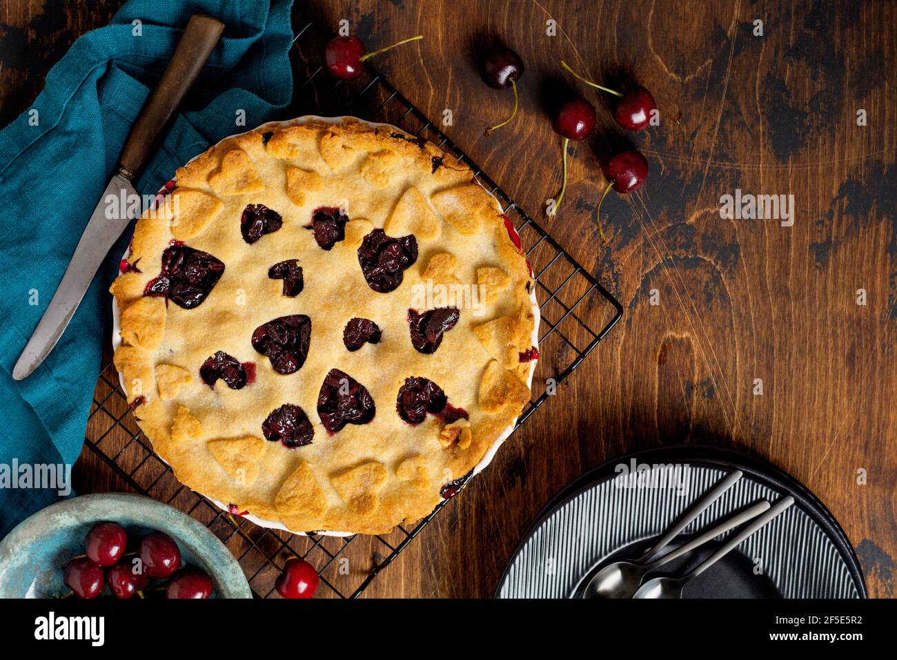 Kirschkuchen lecker hausgemacht mit Herzen auf Holzhintergrund. Valentinstag Backwaren. Draufsicht Stockfoto