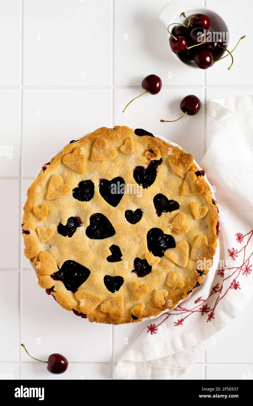 Cherry Pie lecker hausgemacht mit Herzen auf einem hellen weißen schönen Keramik-Hintergrund. Valentinstag Backwaren. Draufsicht Stockfoto