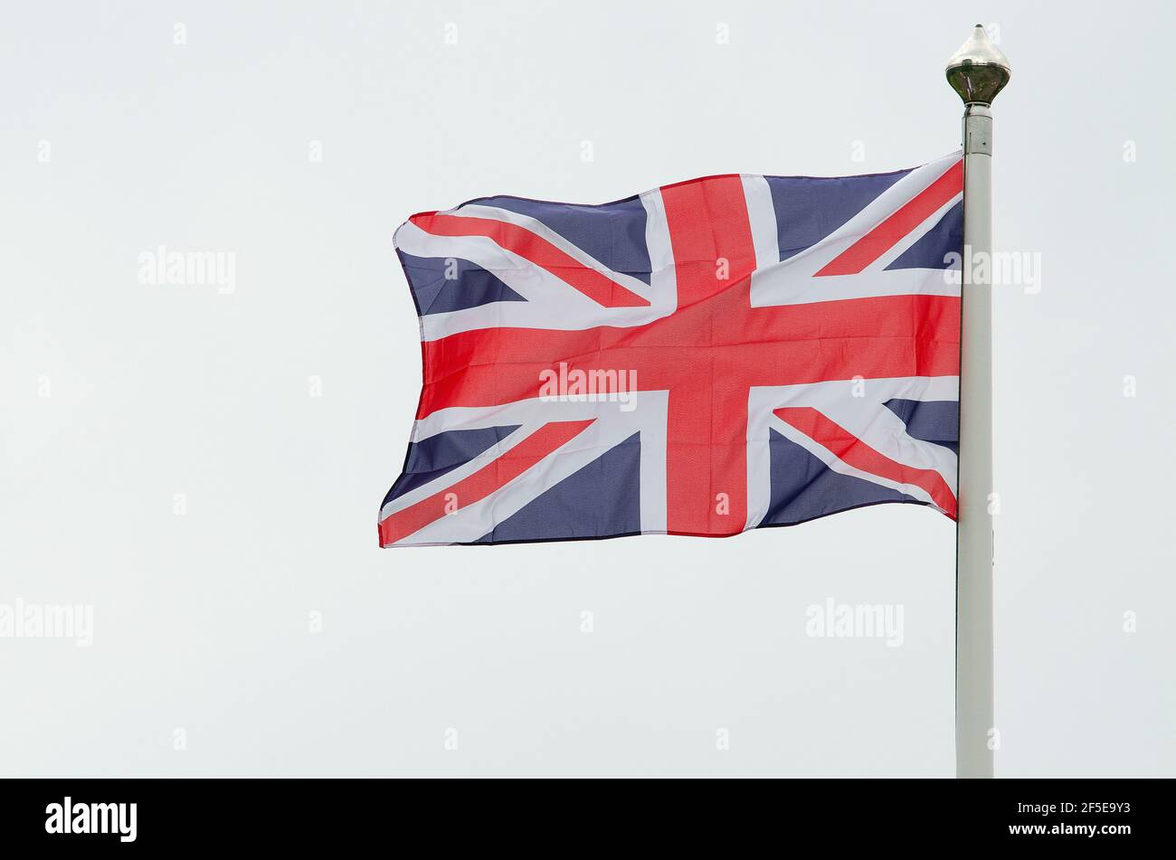 Winkende britische Flagge aus dem vereinigten Königreich auf einem weißen Himmel Stockfoto