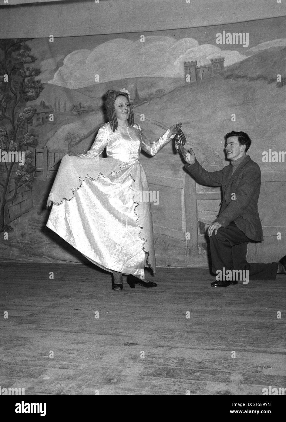 1956, historisch, auf einer hölzernen Bühne, zwei Schauspieler, eine junge Dame und ein Mann in den Kostümen ihrer Charaktere in dem Stück, Jack & the Beanstalk, England, Großbritannien. Eine uralte Volksgeschichte, die zuerst als englisches Märchen veröffentlicht wurde, „The Story of Jack Spriggins and the Enchanted Bean“ im Jahr 1734 und dann 1807 in „The History of Jack and the Bean-Stiel“ von Benjamin Tabert. Märchen sind alte Folklore, featuriing mythische Kreaturen; Elfen, Feen, sprechende Tiere, Hexen und Riesen in magischen Geschichten, die weit hergeholt und nicht wahr sind und in der Tat möglicherweise nicht wahr sein könnten. Stockfoto