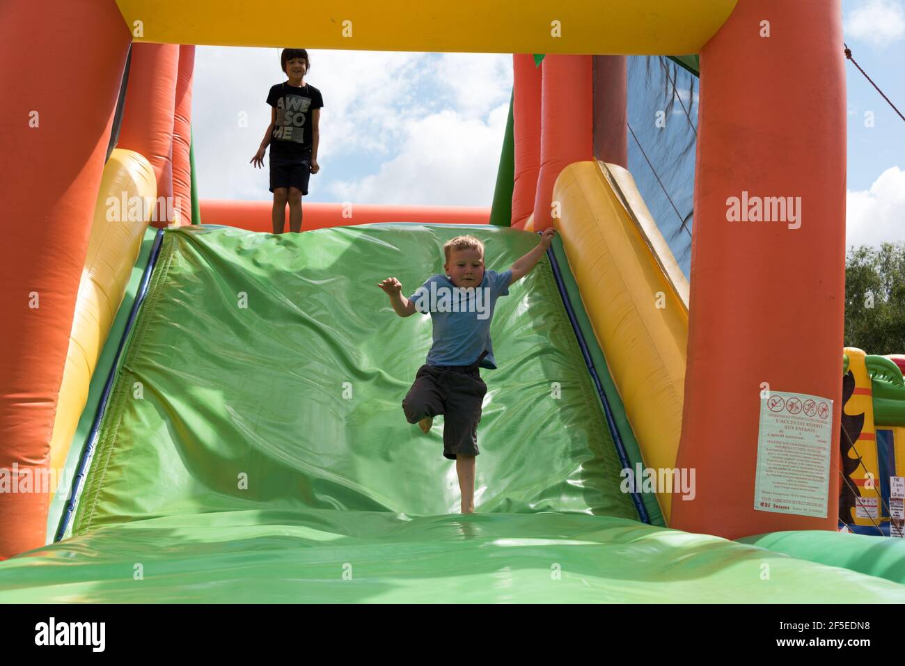Zwei kleine Jungen, die sich auf einer aufblasbaren Hüpfburg amüsieren. Stockfoto