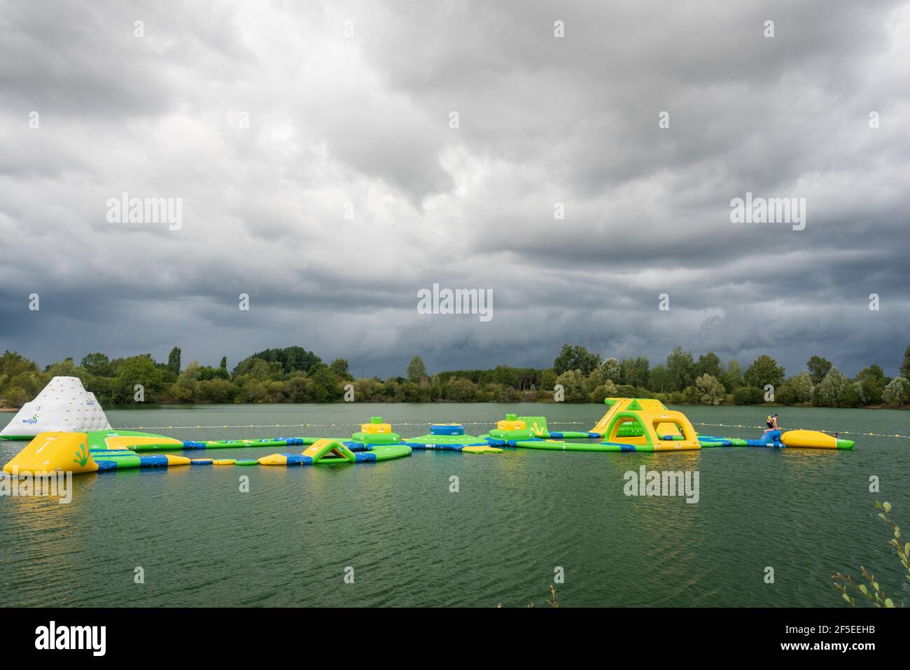 Eine große schwimmende aufblasbare Sturmbahn auf einem Mann gemacht see in Frankreich Stockfoto