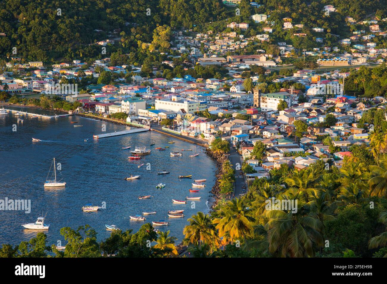 Soufriere, St. Lucia. Blick über die Stadt und den Hafen vom Gipfel des mirador, farbenfrohe Gebäude, die von der untergehenden Sonne beleuchtet werden. Stockfoto
