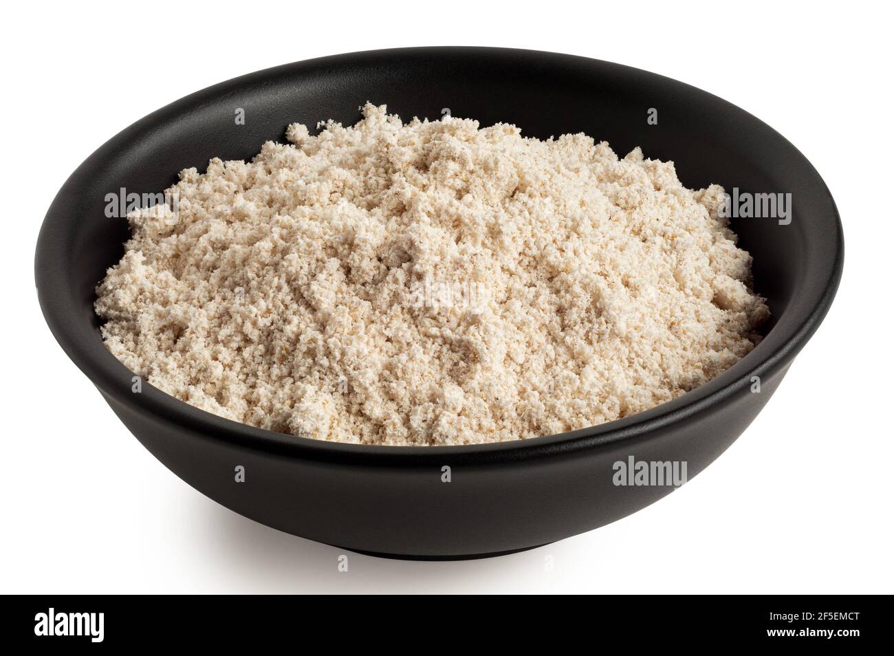 Hafermehl in einer schwarzen Keramikschale isoliert auf weiß. Stockfoto