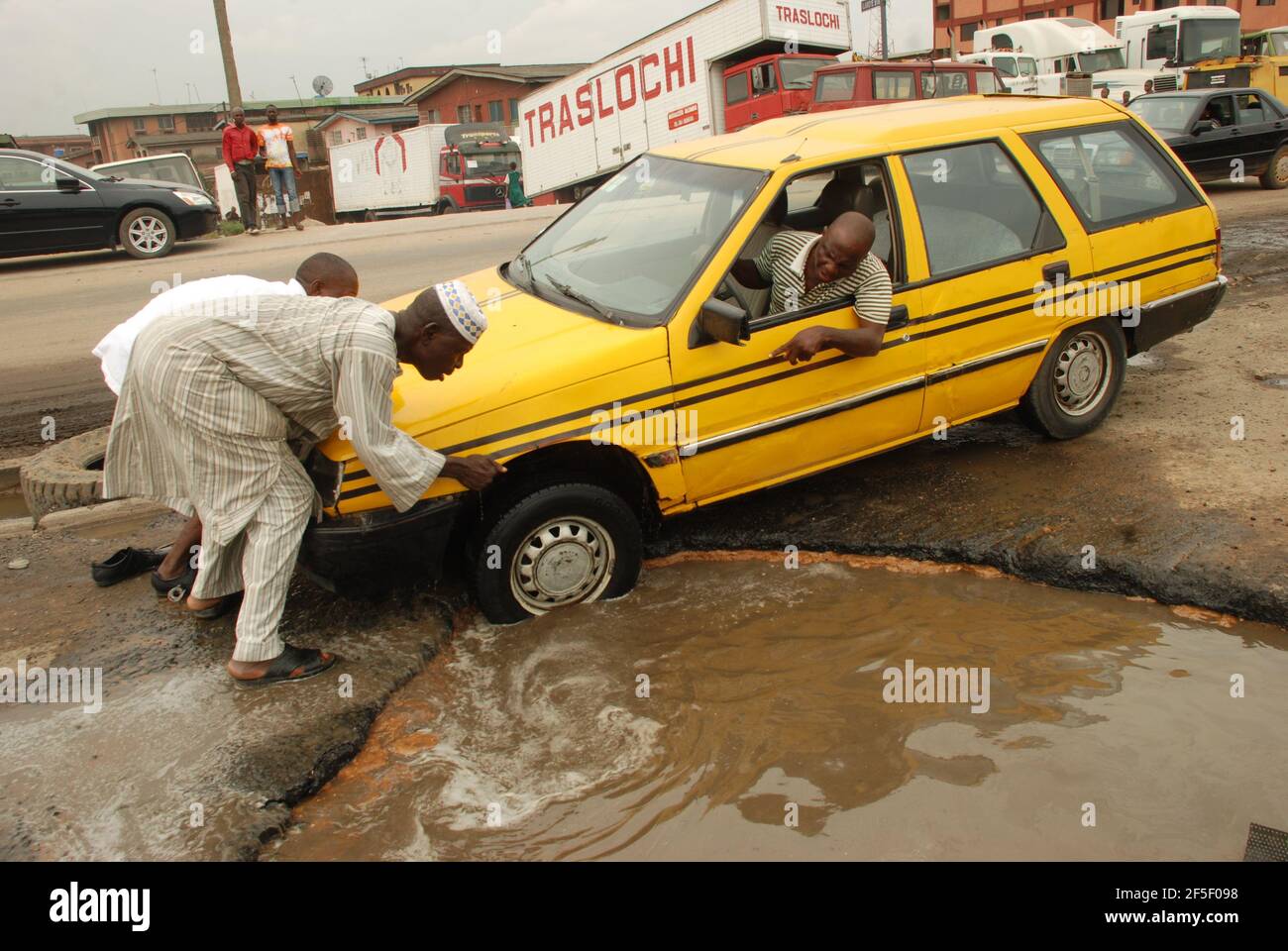 13. Lagos Metro: Ein Taxifahrer kämpft mit seinem Auto auf der schlechten Straße von Lagos. Stockfoto