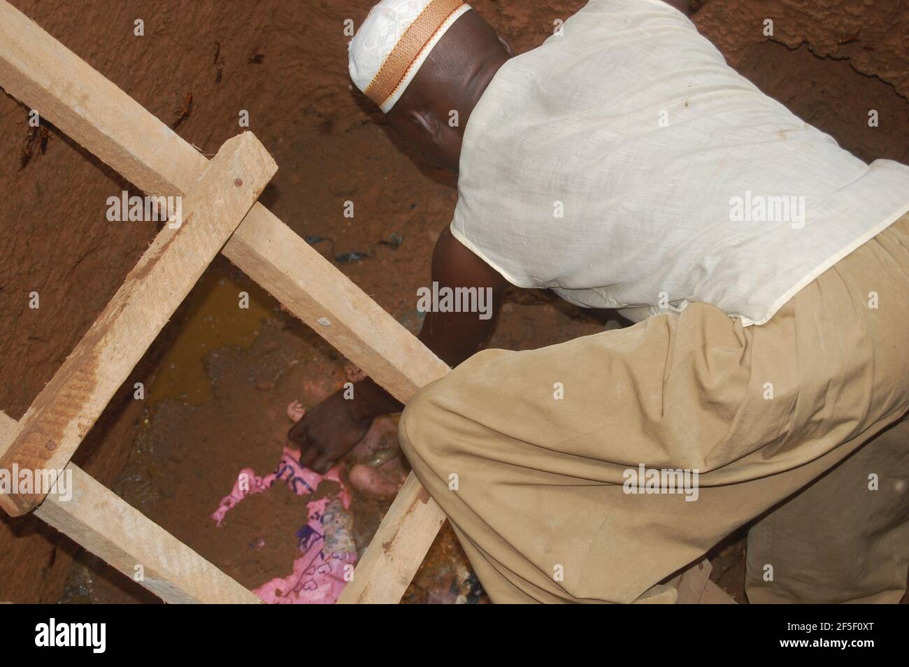 2. Verlassenes Baby: Ein Mann, der das neugeborene Baby aus der Grubentoilette in Lagos, Nigeria, rettet. Stockfoto