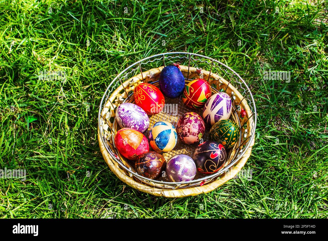 Defokussieren Sie bunte ostereier. Dekoriert pysanka und krashanka. Holzkorb Mit Ostereiern Im Grünen Gras. Nahaufnahme. Festlich. Traditionell Stockfoto