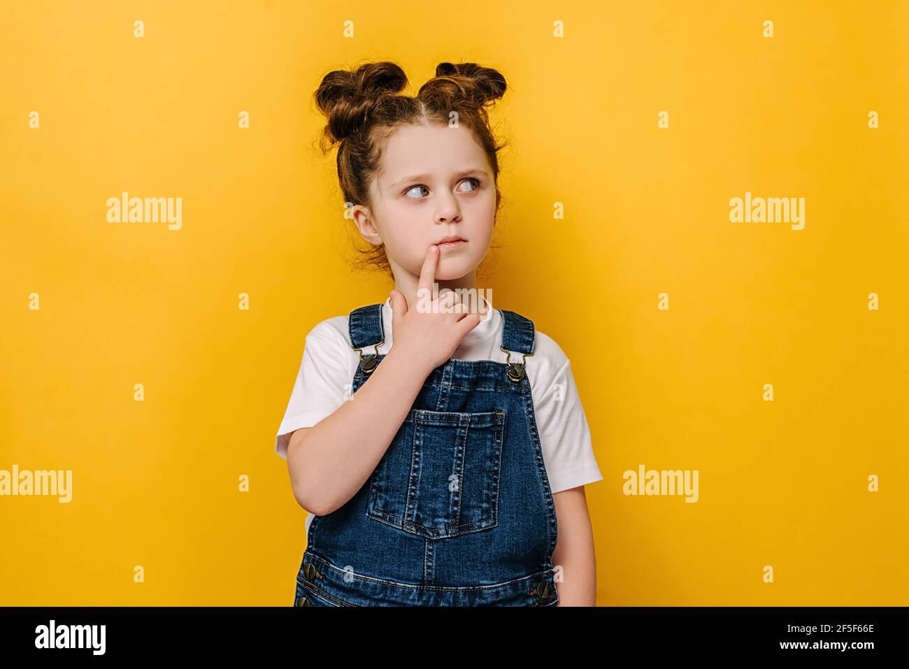 Nachdenklich kleine Vorschulmädchen Kind berühren Kinn mit Finger denken oder erwägen, nachdenklich schöne kleine Kind Entscheidungen vorstellen Idee Stockfoto