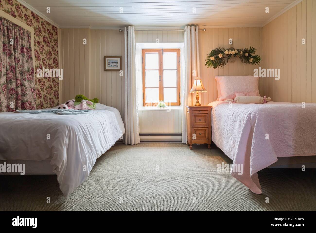 2 Einzelbetten und Nachttisch aus Kiefernholz im Gästezimmer Mit grünem Teppich im Obergeschoss in einem alten 1807 Haus im Cottage-Stil Stockfoto
