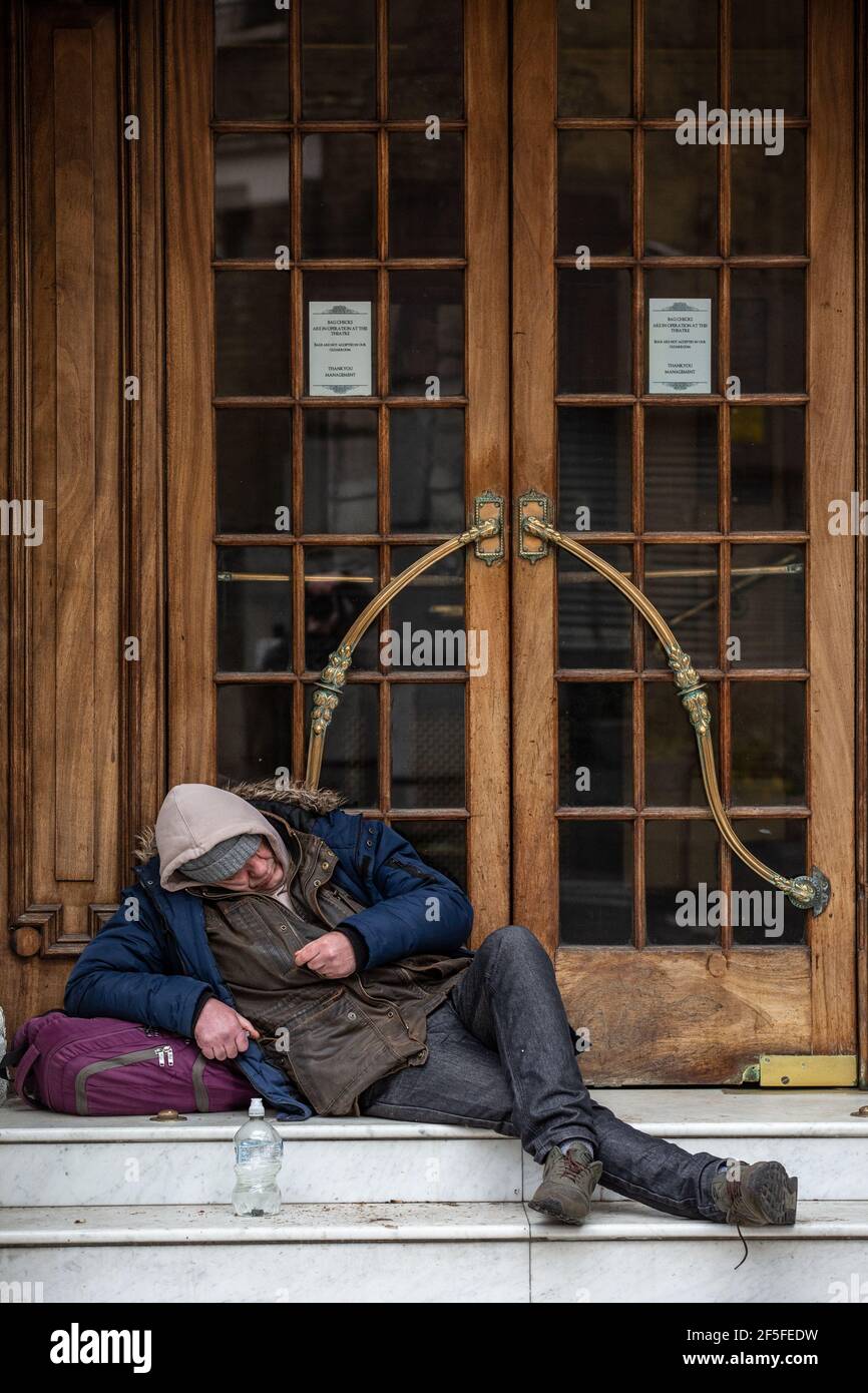 Ein Obdachloser sitzt auf den Stufen des St Martin's Theatre im Londoner West End, bevor die Coronavirus-Sperre die Produktion der Mousetrap inszenierte. Stockfoto