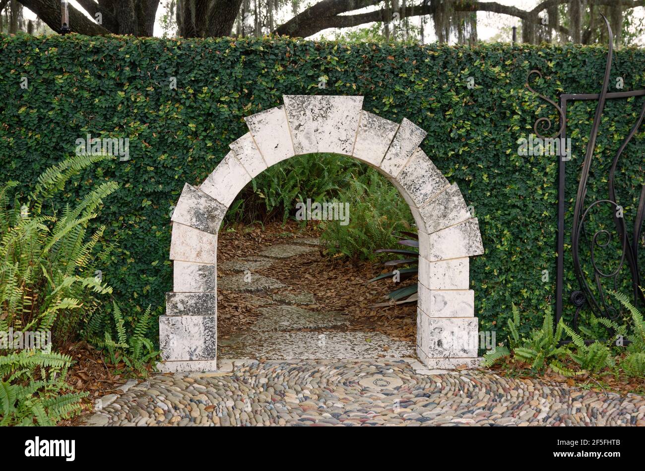 Hängematte Hollow Children's Garden, das Gateway Kindergröße gewölbten Eingang, Stein in Hecke, Mosaik-Pfad, Entdeckung-basierte Lernen, Florida, Bok Tower Ga Stockfoto