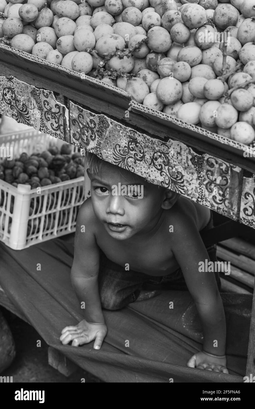 Ein kleiner Junge versteckt sich unter einer Kartoffel ausgeht, CO2-Markt, Cebu City, Cebu, Philippinen Stockfoto