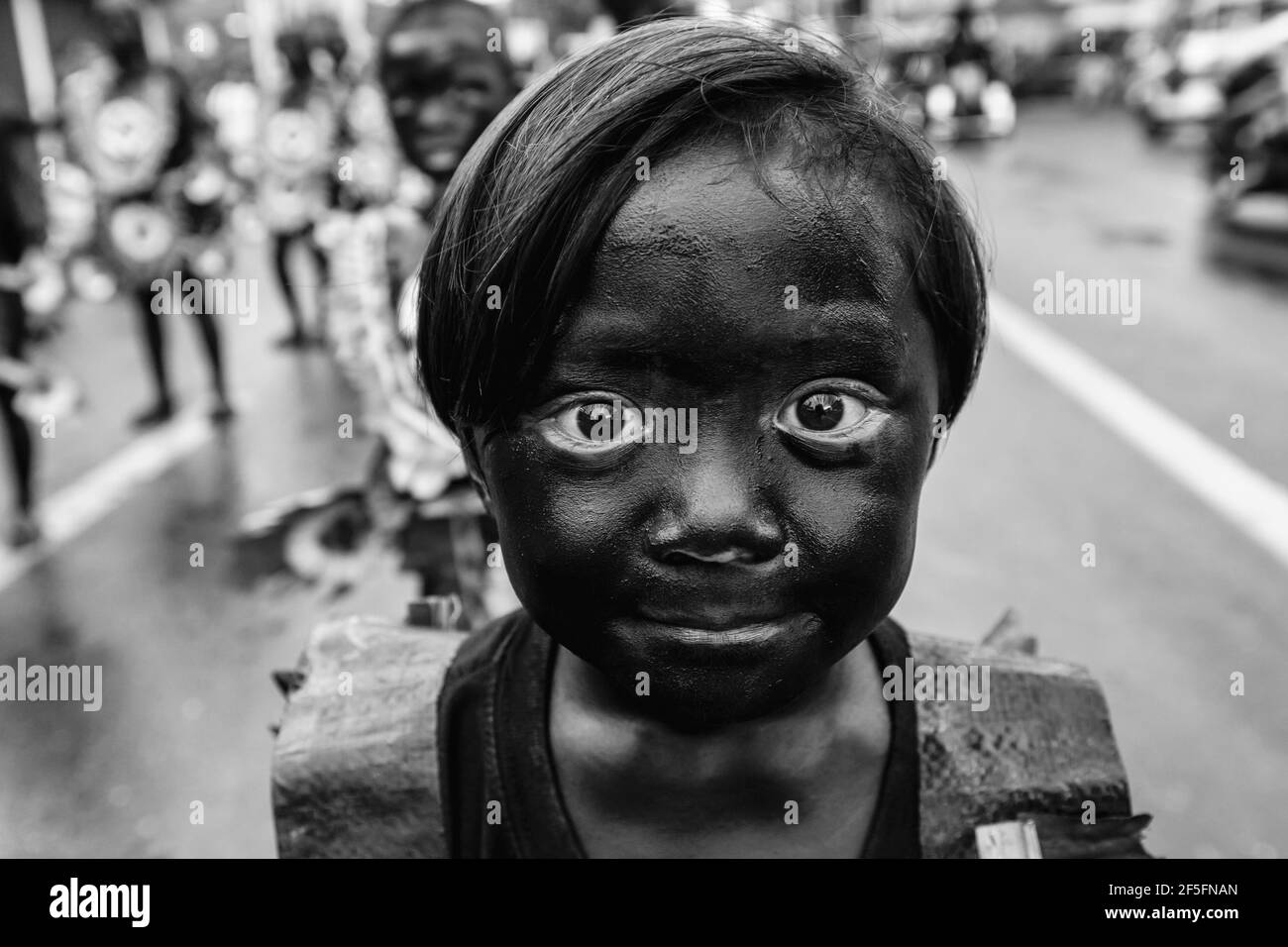 Ein ‘geschwärztes’ Kind nimmt an EINER Kinderparade während des ATI-Atihan Festivals, Kalibo, Panay Island, Provinz Aklan, Philippinen, Teil. Stockfoto