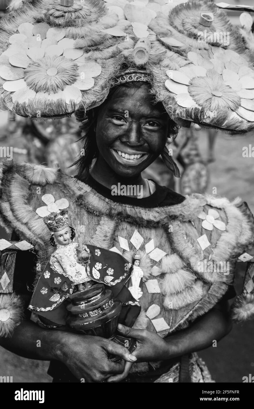 Einheimische In Tribal-Kostümen Parade Durch Die Straßen Von Kalibo Mit Santo Nino Statuen Während Des Ati-Atihan Festivals Auf Den Philippinen. Stockfoto