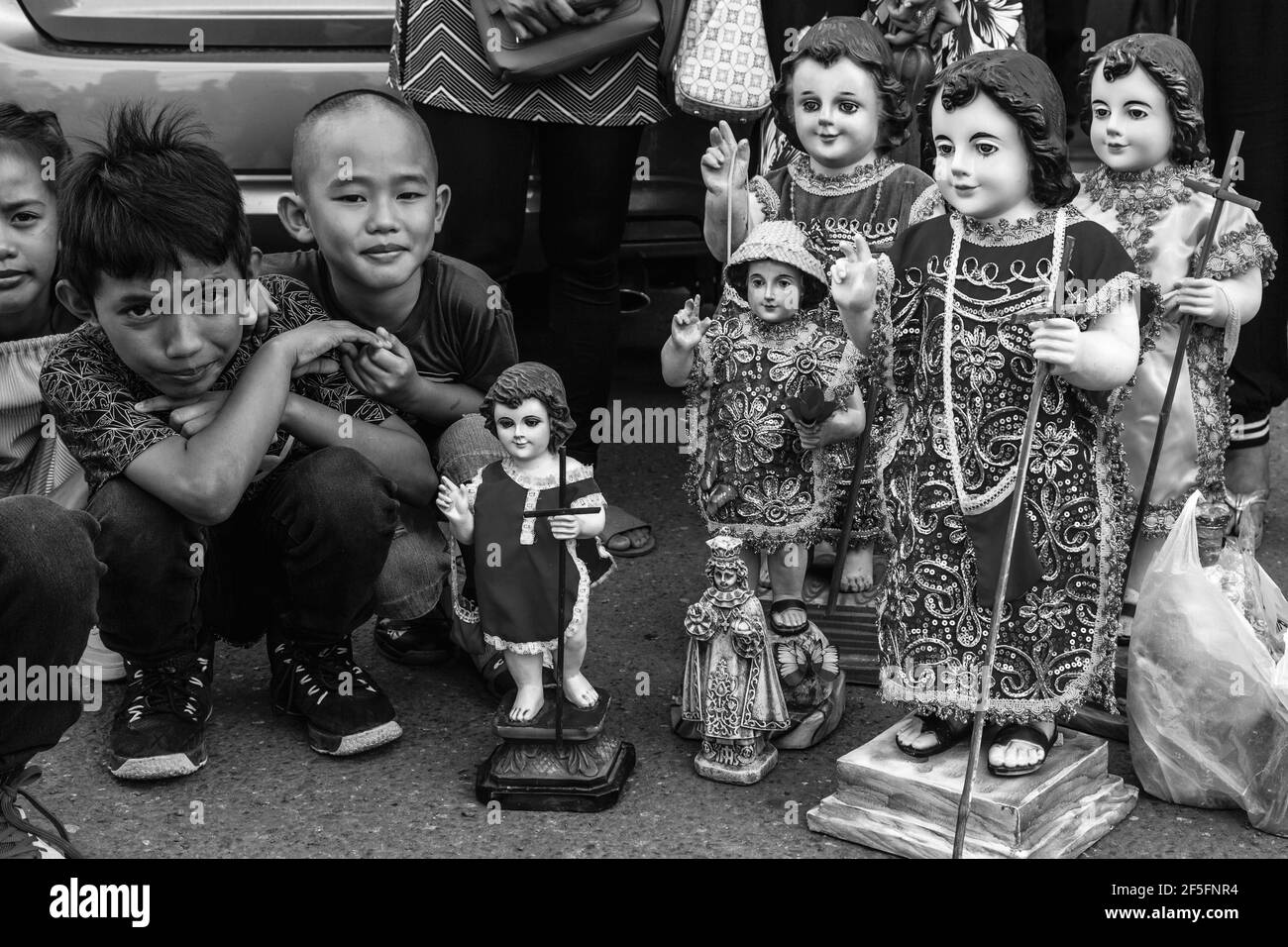 Lokale Kinder Warten Mit Ihren Santo Nino Statuen Auf Die Ankunft Auf Dem Meer Der Replik Santo Nino De Cebu, Dinagyang Festival, Iloilo, Philippinen. Stockfoto