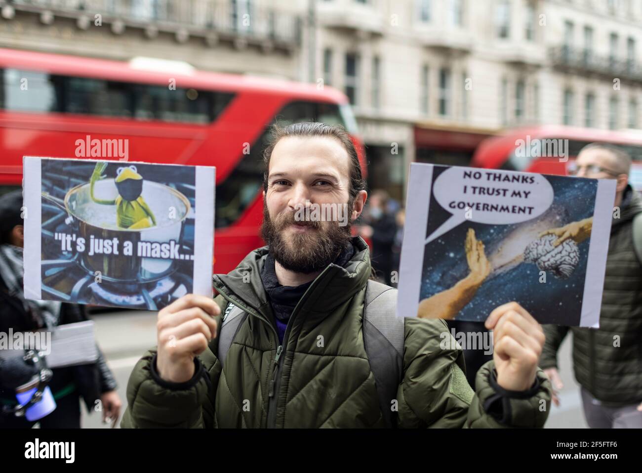 Anti-Lockdown und Anti-Covid-19-Impfprotest, London, 20. März 2021. Protestler mit zwei Plakaten. Stockfoto