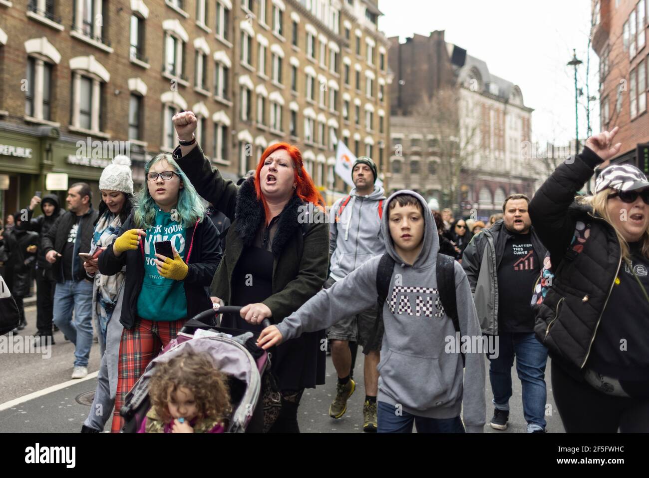 Anti-Lockdown und Anti-Covid-19-Impfprotest, London, 20. März 2021. Eine Familie marschiert mit Menschenmenge. Stockfoto