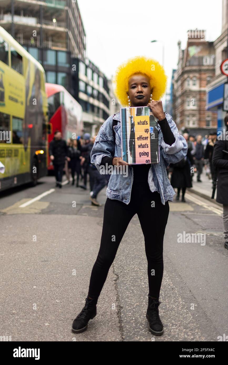 Anti-Lockdown und Anti-Covid-19-Impfprotest, London, 20. März 2021. Porträt einer schwarzen Frau mit gelbem Afro und Plakat. Stockfoto