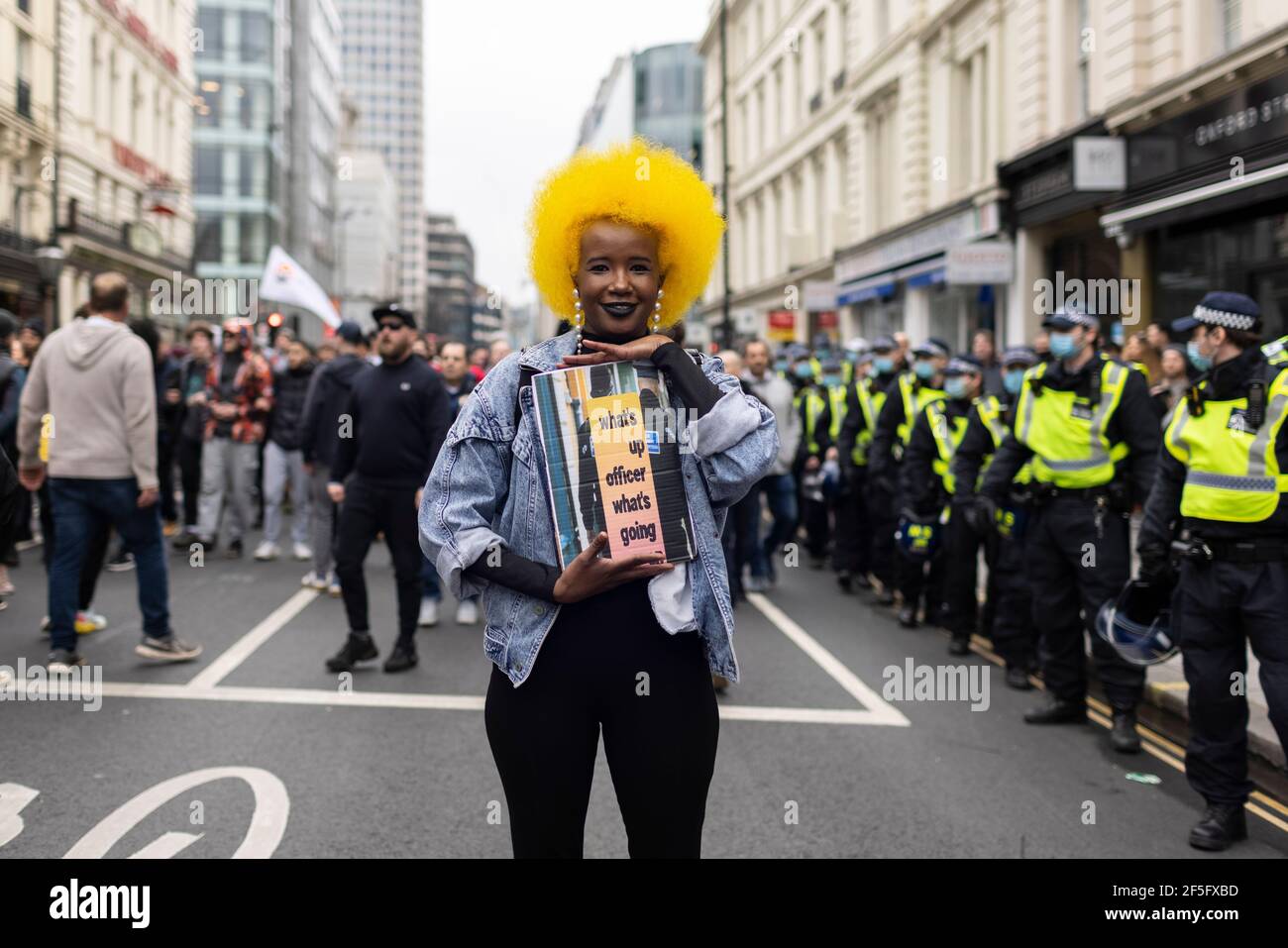 Anti-Lockdown und Anti-Covid-19-Impfprotest, London, 20. März 2021. Porträt einer schwarzen Frau mit gelbem Afro und Plakat. Stockfoto