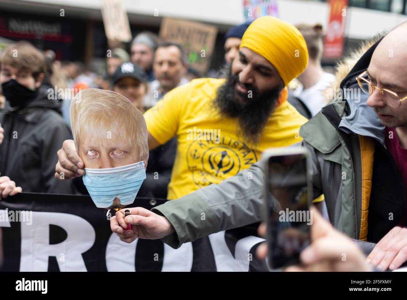 Anti-Lockdown und Anti-Covid-19-Impfprotest, London, 20. März 2021. Demonstranten verbrennen eine Gesichtsmaske von Boris Johnson. Stockfoto
